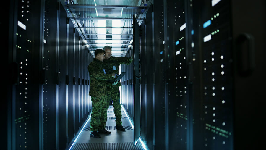 Two Military Men Work with Open Server Rack Cabinet